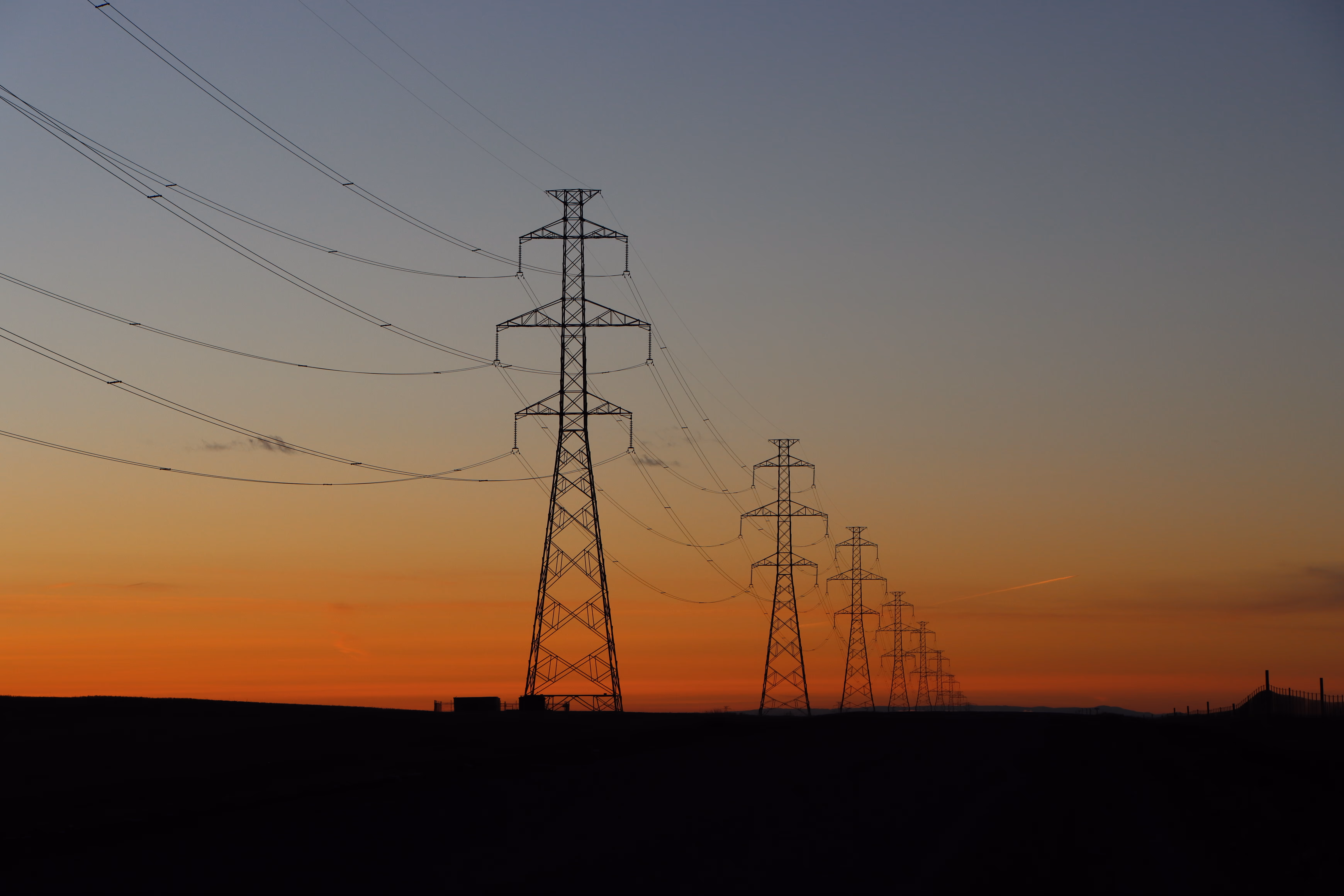 夕暮れの送電鉄塔と高圧線